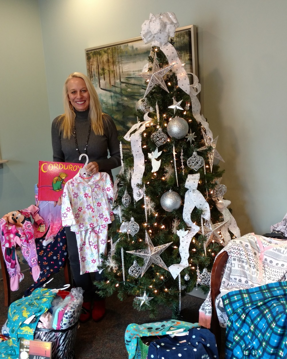 Beverly Stewart, M.Ed., Director of Back to Basics Learning Dynamics with just a few of the dozens of pajamas and books collected by Back to Basics staff members for the Nationwide Chapter of he Pajama Program.